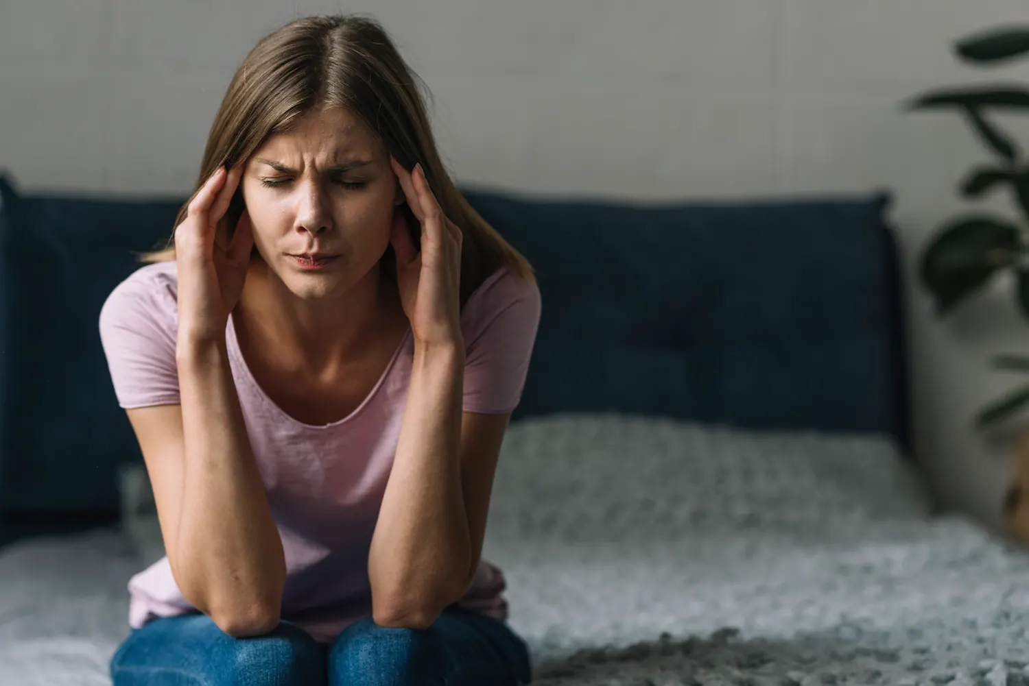 woman sitting in couch suffer migraine pain