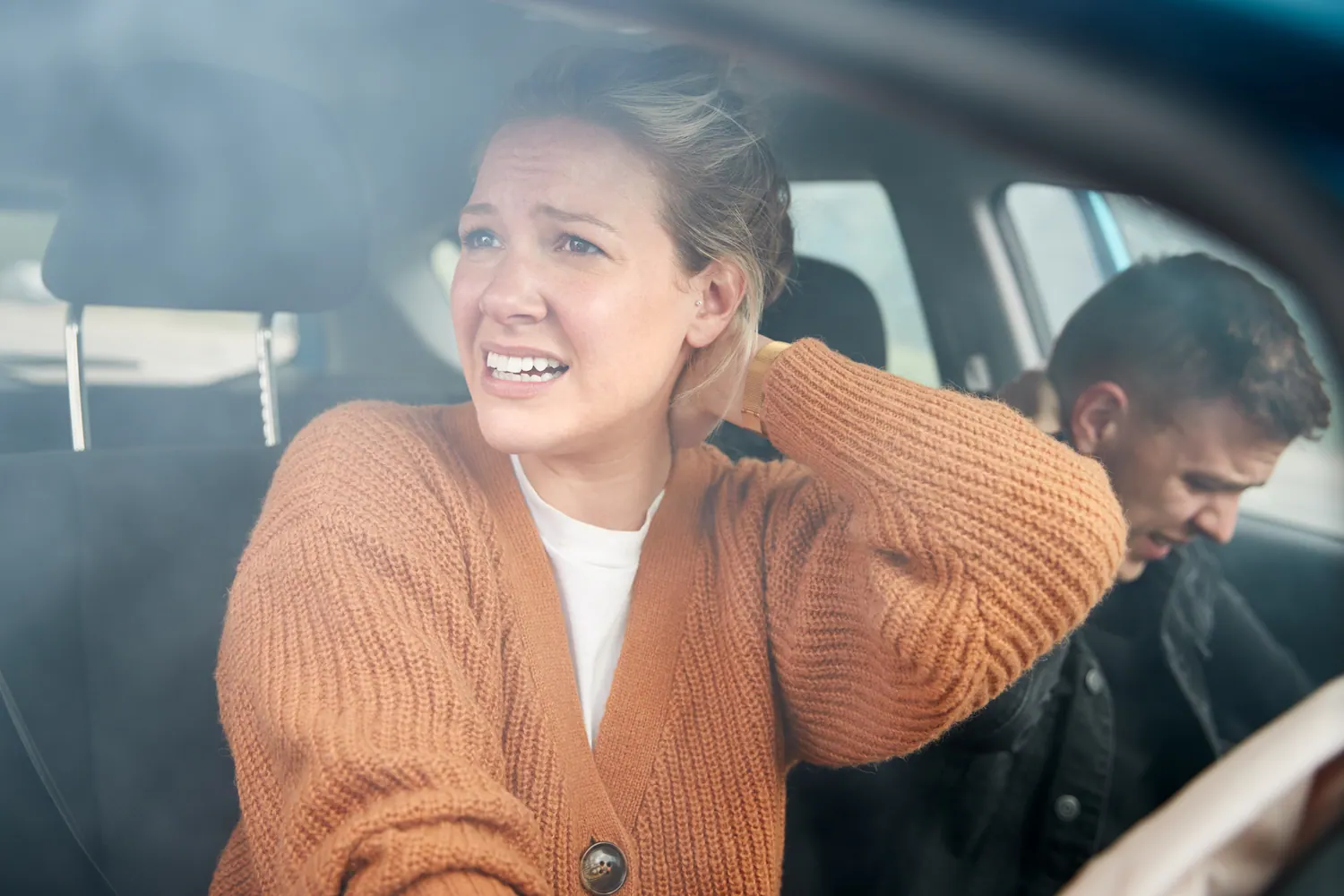 a woman and a man suffering from neck pain cause of car accident