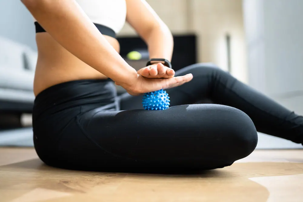 a woman using a trigger point tool om her legs