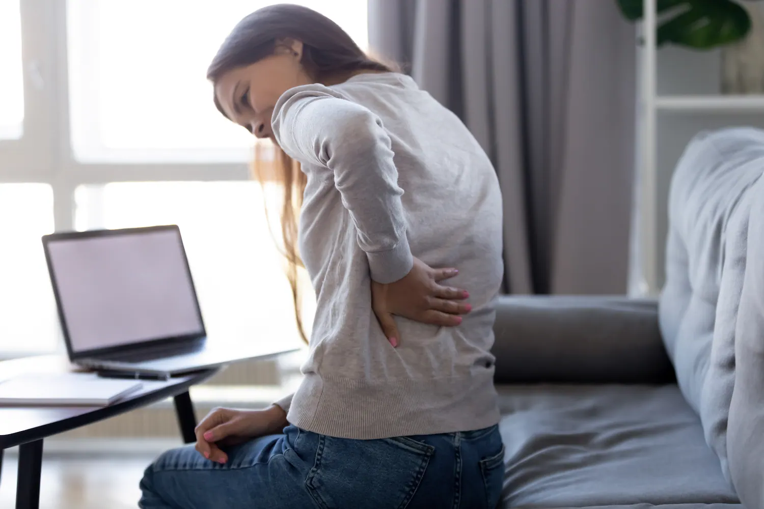 a woman having a back pain during her work