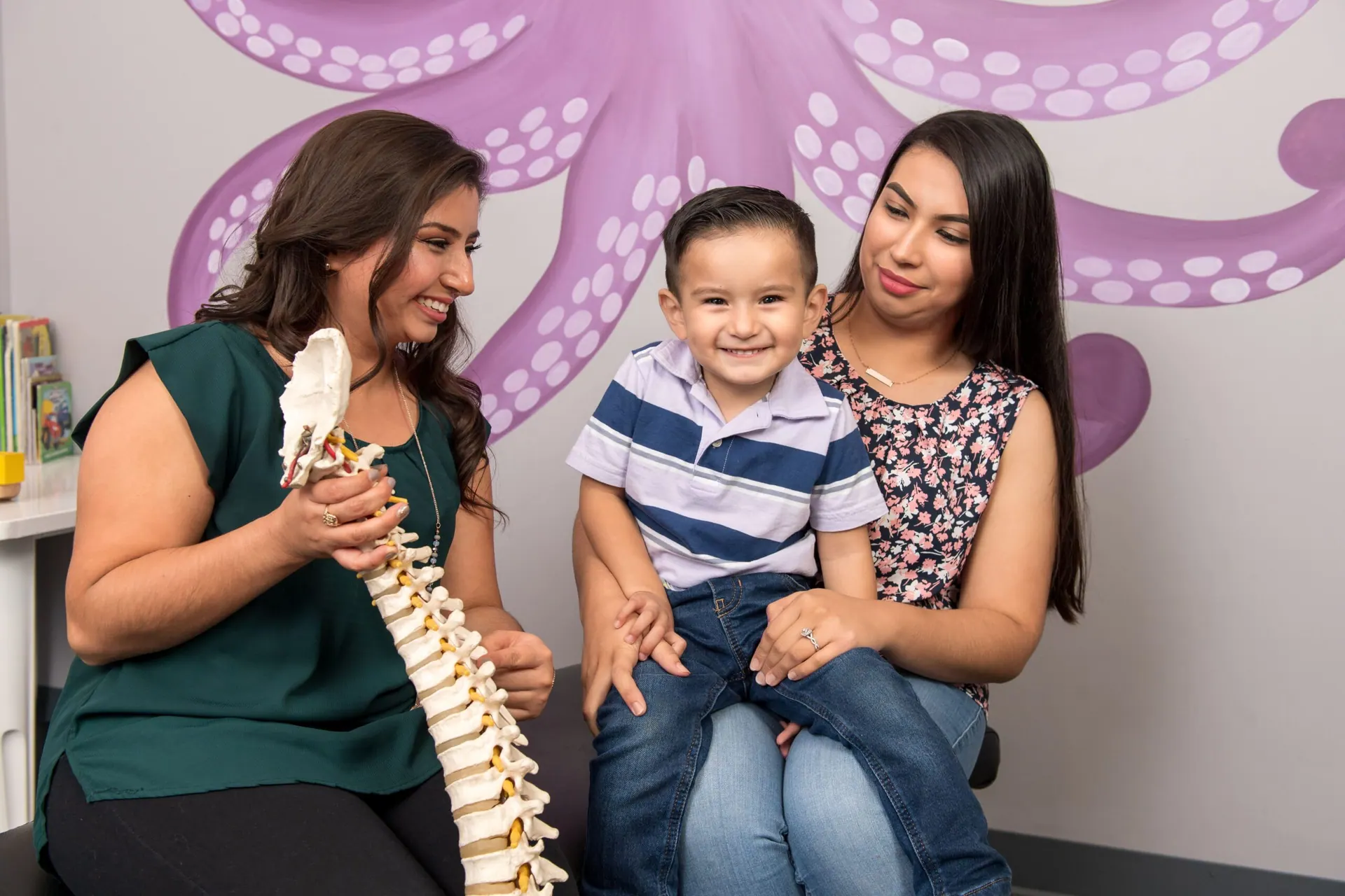 Dr Martha Manzanarez demo the spine model to mother and son